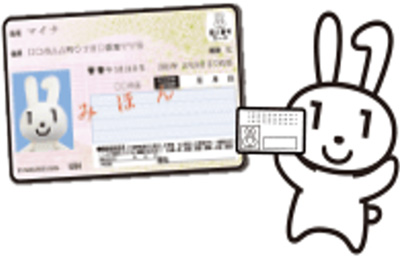 マイナンバーカードの見本を持っているマイナちゃん